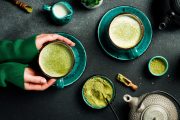Ženské ruce drží šálek s matcha nápojem