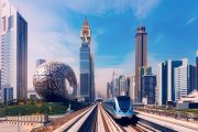 Ilustrační obrázek dubajského metra projíždějícího mezi mrakodrapy