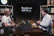 Moderátor Martin Zika a host Václav Muchna sedí naproti sobě u velkého dřevěného stolu. V pozadí mezi nimi velká černá obrazovka s logem BusinessInfo.cz a z každé strany je knihovna.