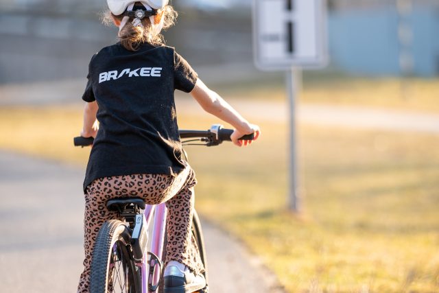 mladá cyklistka nakole s brzdami brakee